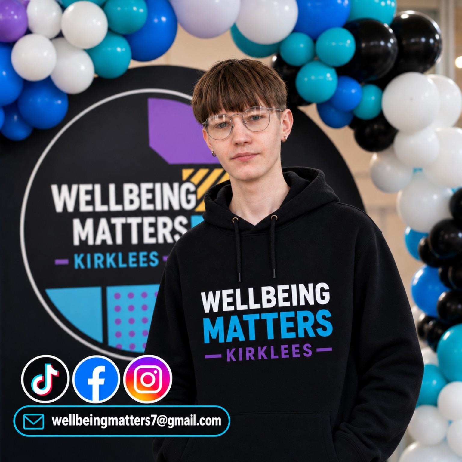 Jason wearing a Wellbeing Matters Kirklees hoodie in front of the project logo